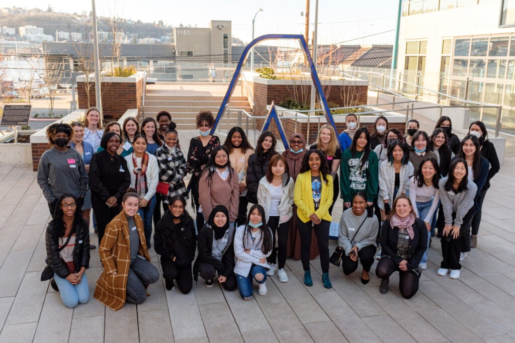 Photo of the SPIN Girls Fellows standing in front of Adaptive's Headquarters with Volunteers